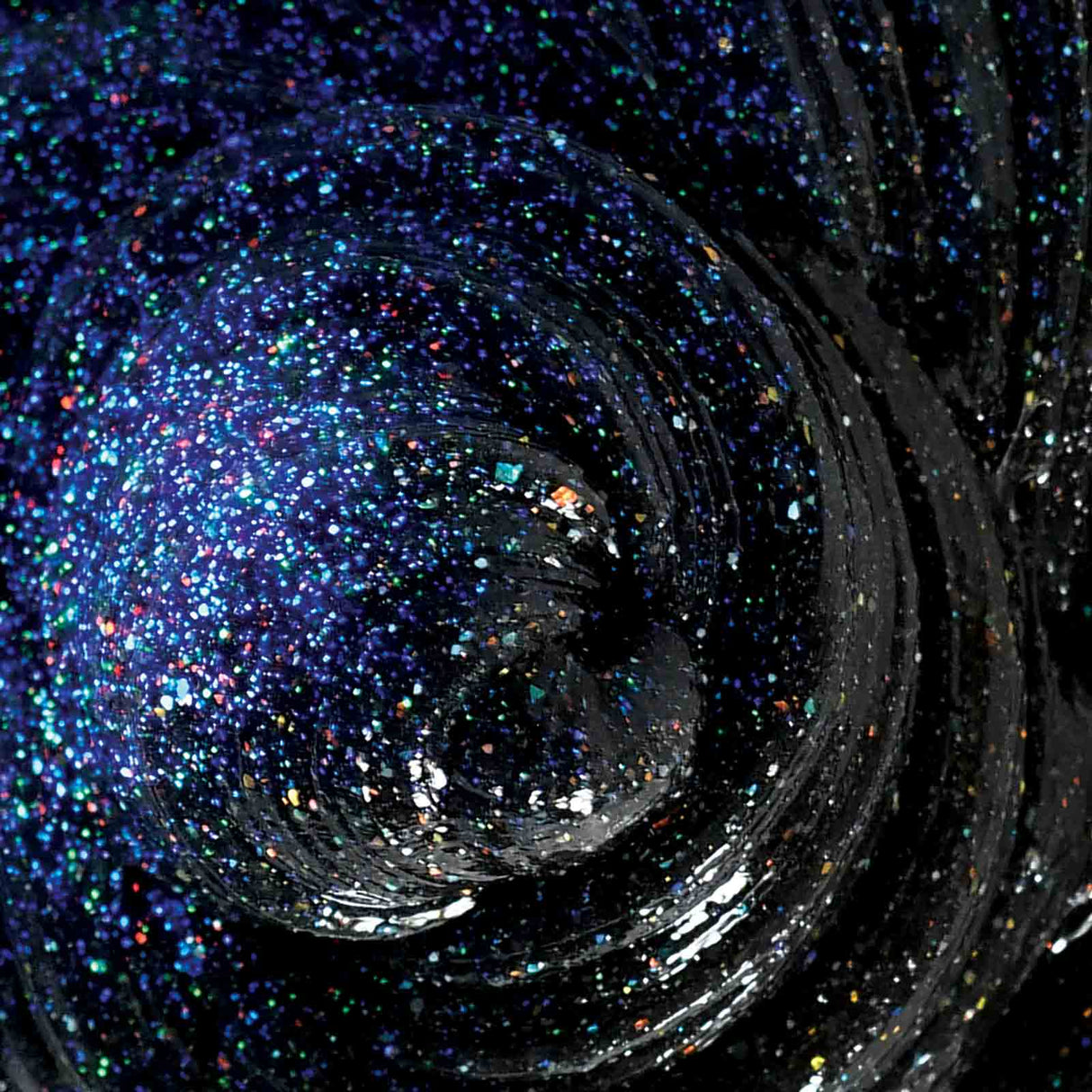 Cosmic Glows Star Dust Thinking Putty black with holographic glitter shimmering in light and glowing in the dark.