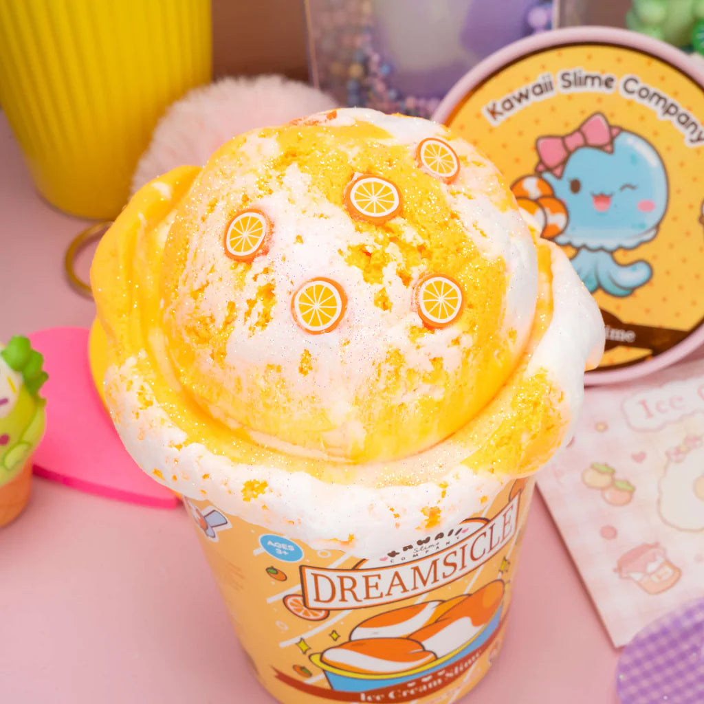 Dreamsicle Ice Cream Slime shaped like orange and cream ice cream with citrus slice decorations in a branded cup.