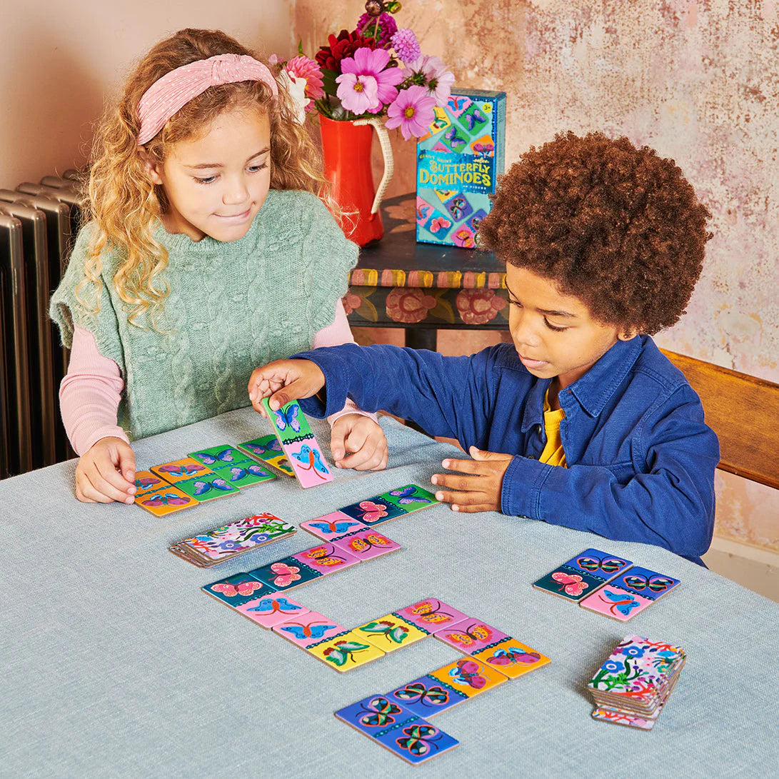 Two children playing Giant Shiny Butterfly Dominoes with colorful holographic butterfly tiles on a table.