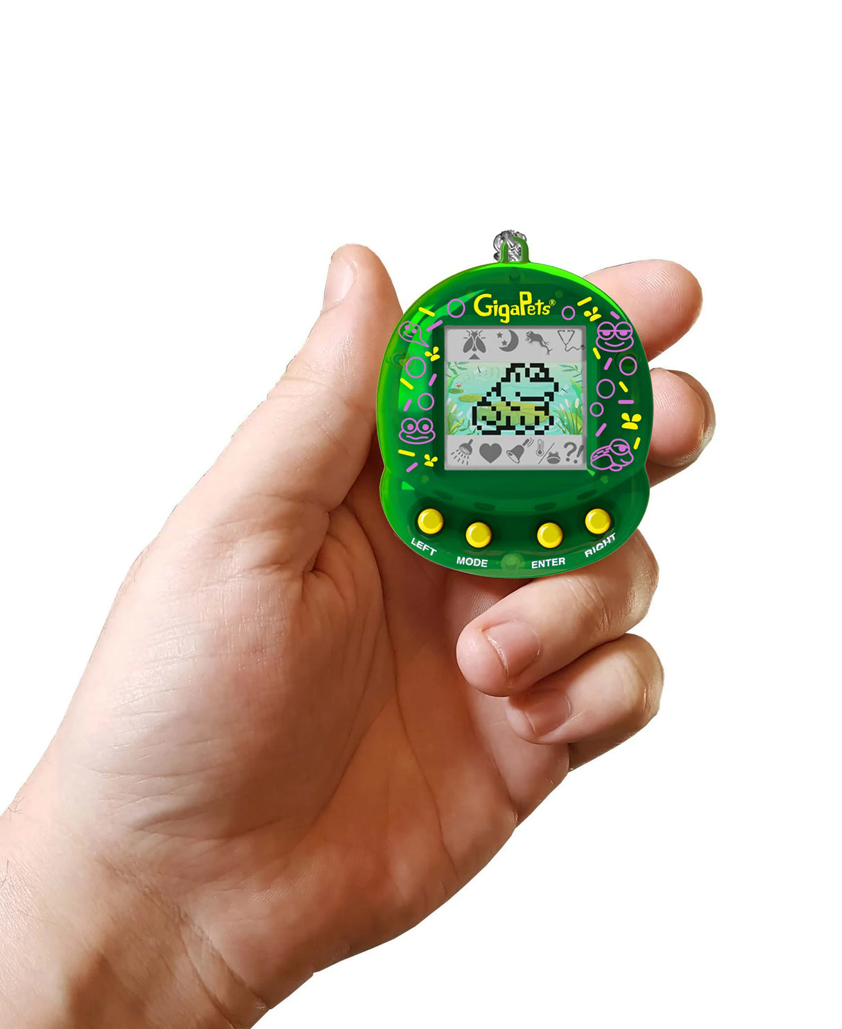 Hand holding a green GigaPets Floppy Frog virtual pet toy with pixelated frog on screen and control buttons below.