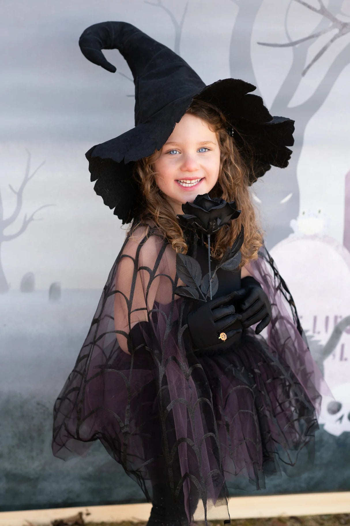 Child wearing Spider Witch Tutu & Cape | Size 5-6 with spider web overlay tutu and matching cape.