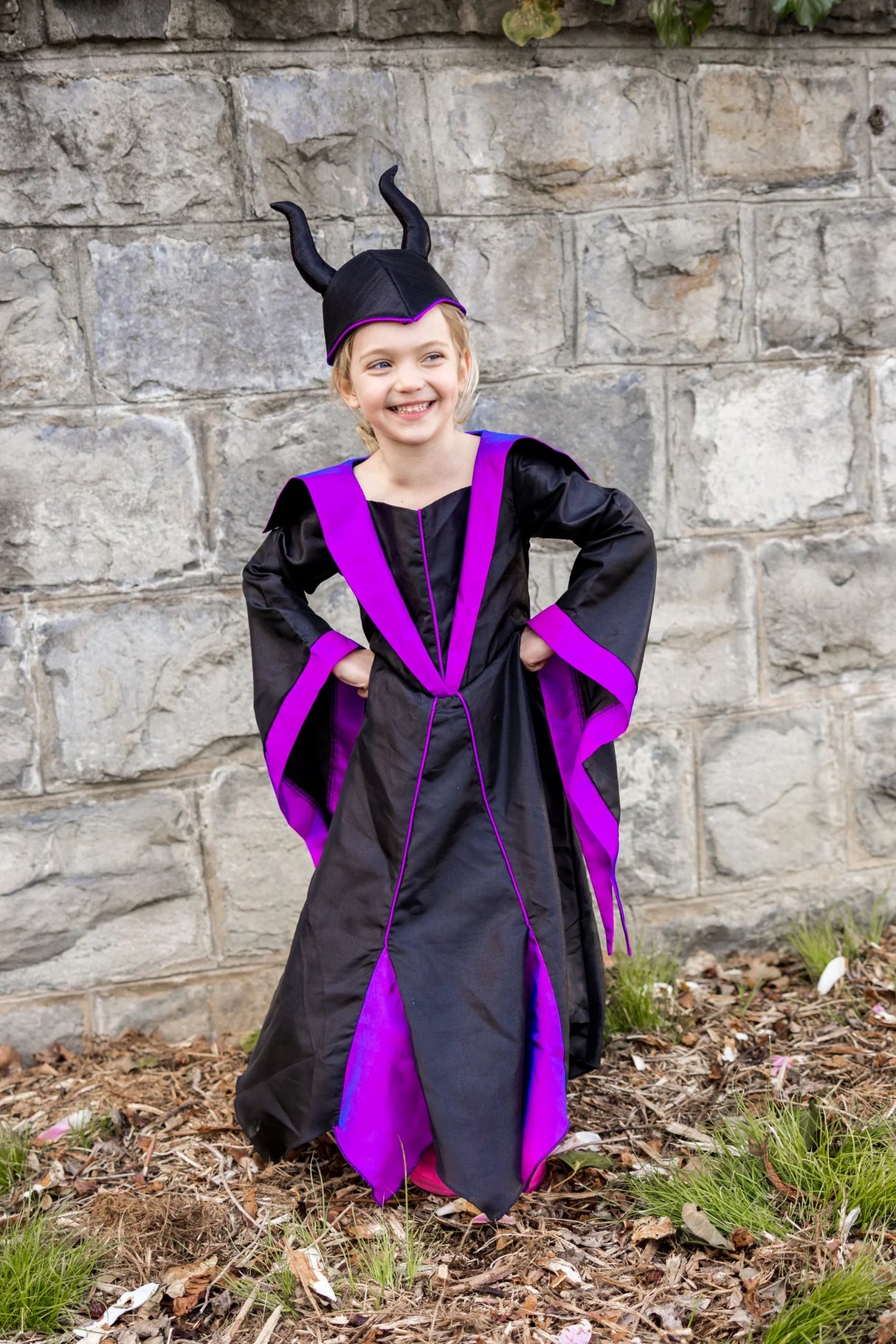 Child wearing Villian Princess Dress & Headpiece in black and purple with horned headpiece, size 5-6, standing outdoors.
