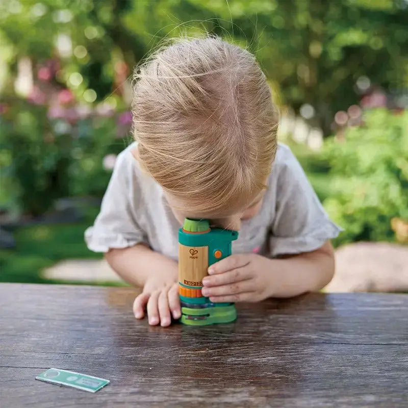 Child using the Field Microscope outdoors, exploring nature with the portable eco-friendly bamboo microscope.