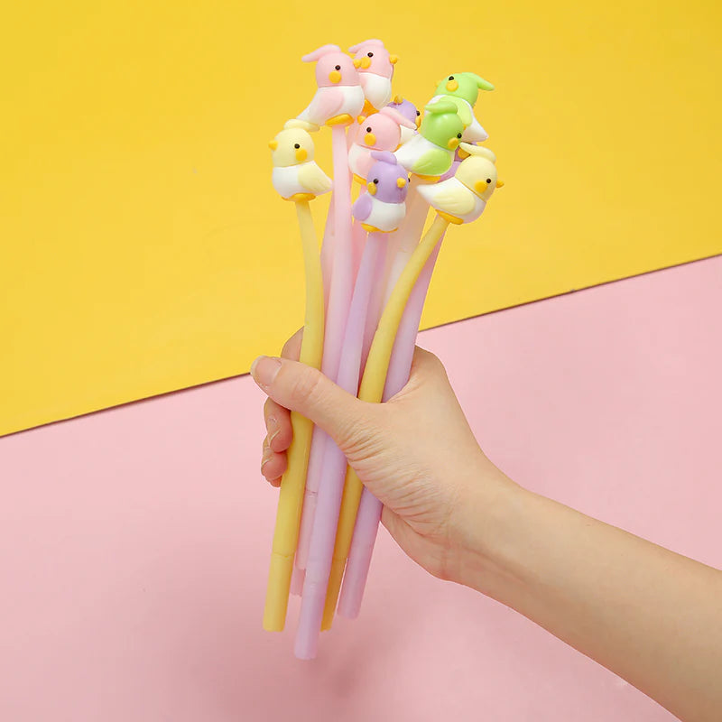 Hand holding assorted styles of Bird Pet Gel Pen with fine tips on pink and yellow background