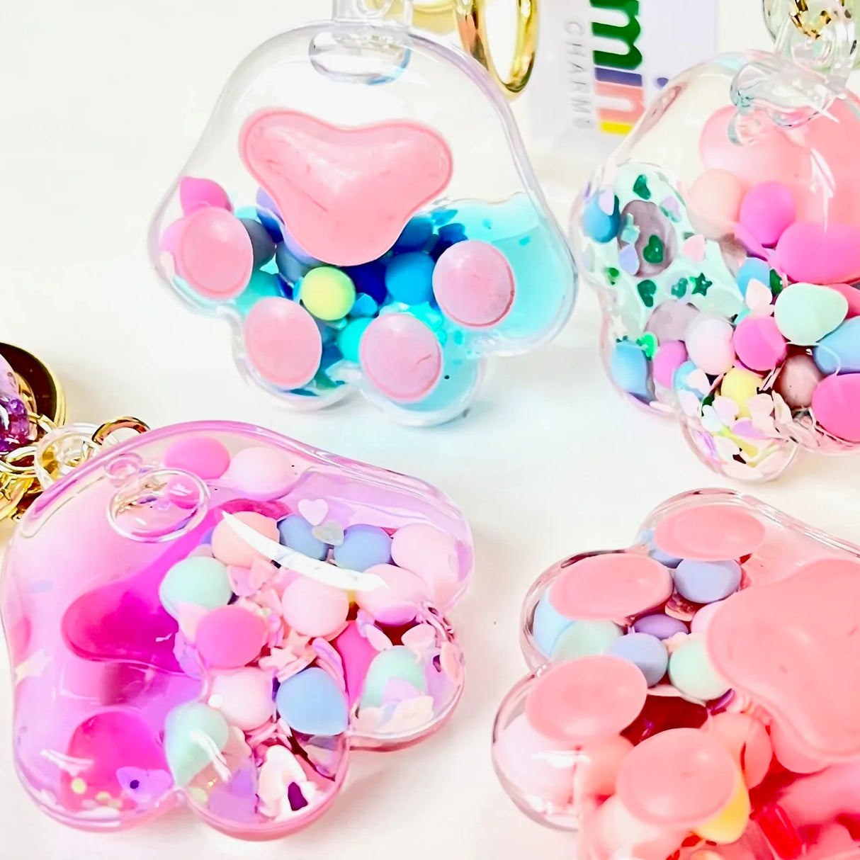 Paw Floaty KeyChain with colorful floating confetti inside clear paw-shaped charm, perfect for backpacks or keys.
