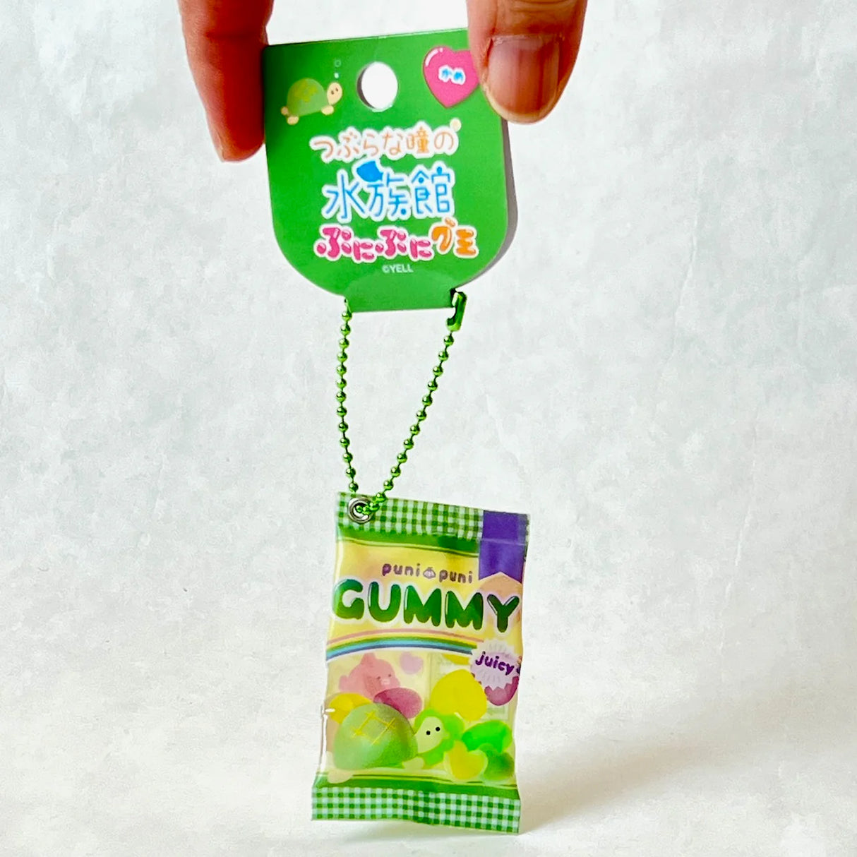 Gummy Turtle Puripuri Keychain showing a cute squeezable gummy bag toy hanging from a green ball chain.