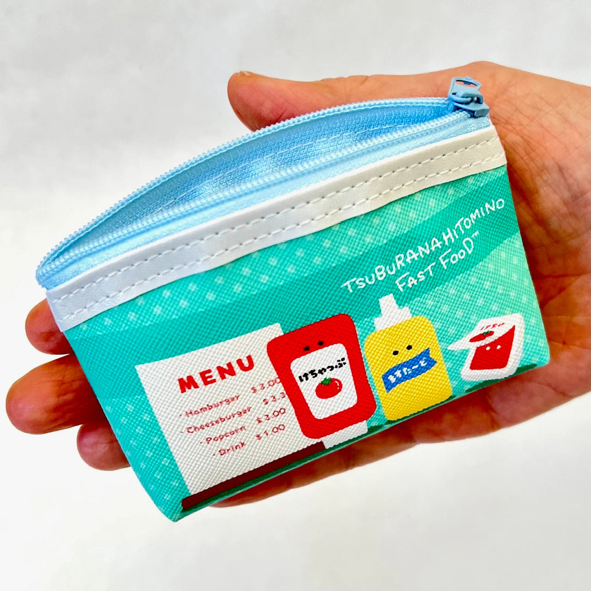 Hand holding a small Fast Food Coin Pouch featuring a colorful fast food sauce design and light blue zipper.