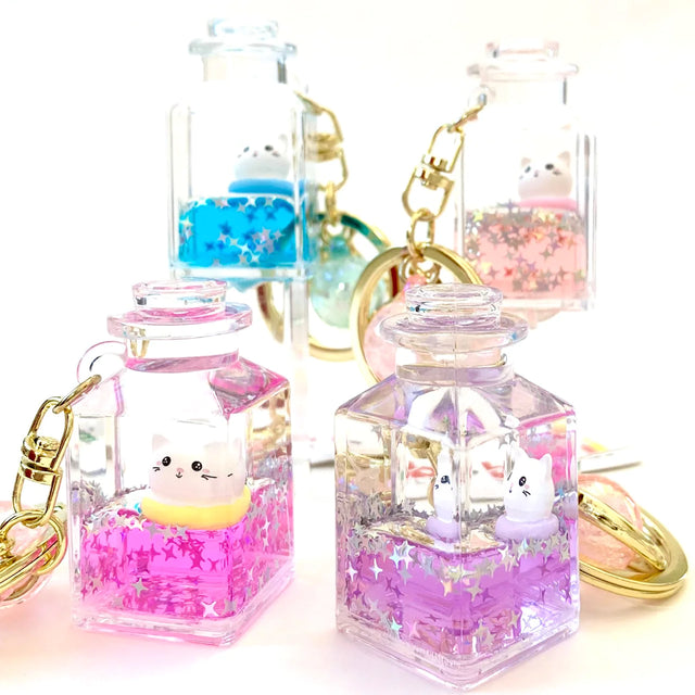 Kitty Jar Floaty KeyChain with colorful liquid and star glitter inside clear jars, each containing a cute cat figure.