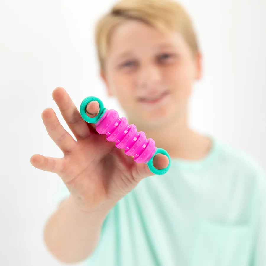 Child holding a bright pink and green Krumples | Fidget toy designed for soothing sensory play and fun movement.