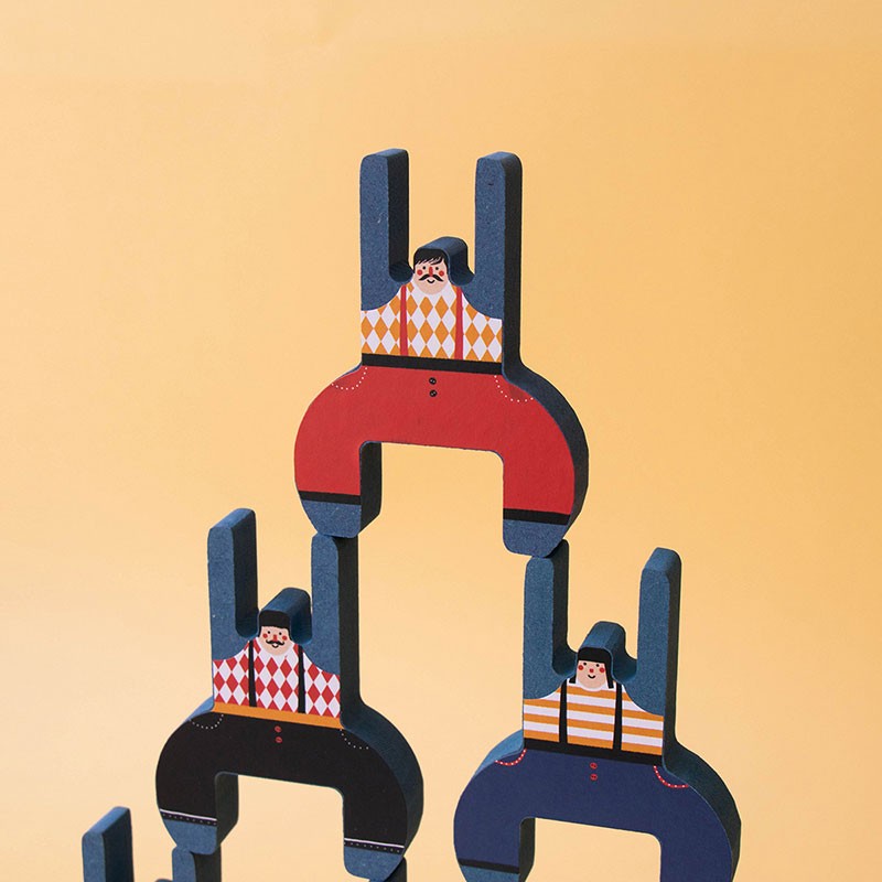 Acrobat Balancing Game showing colorful wooden acrobats stacked to form a balanced human tower against a beige background.