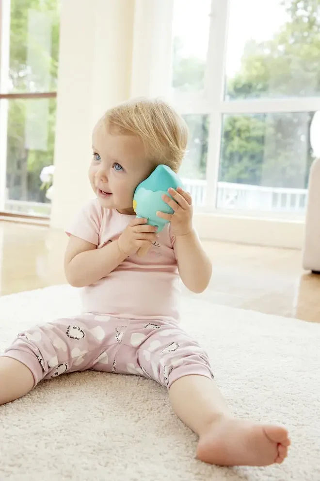 Baby playing with the Magic Music Conch, a toy that plays soothing melodies and records voice with fun effects.