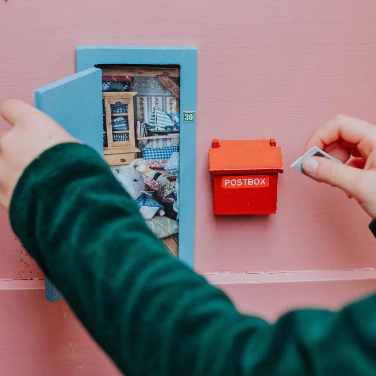 Sam & Julia | DIY Little Mouse Door showing miniature blue door and red letterbox with hand placing mail.