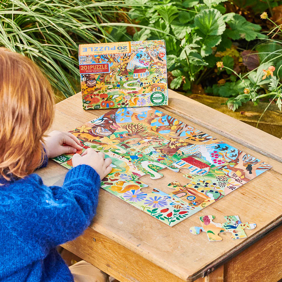 Child assembling colorful 20pc Fairy Cottage Puzzle featuring autumnal fairyland and tiny woodland creatures.