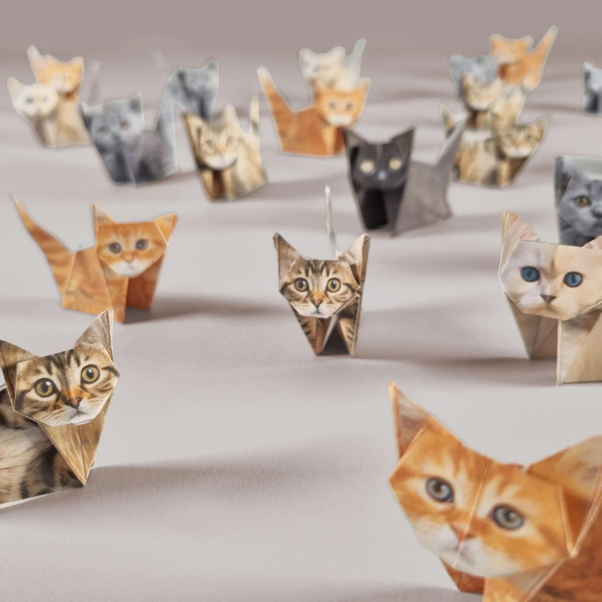 Origami paper cats in various colors and breeds arranged on a surface, perfect for cat lovers and decor.