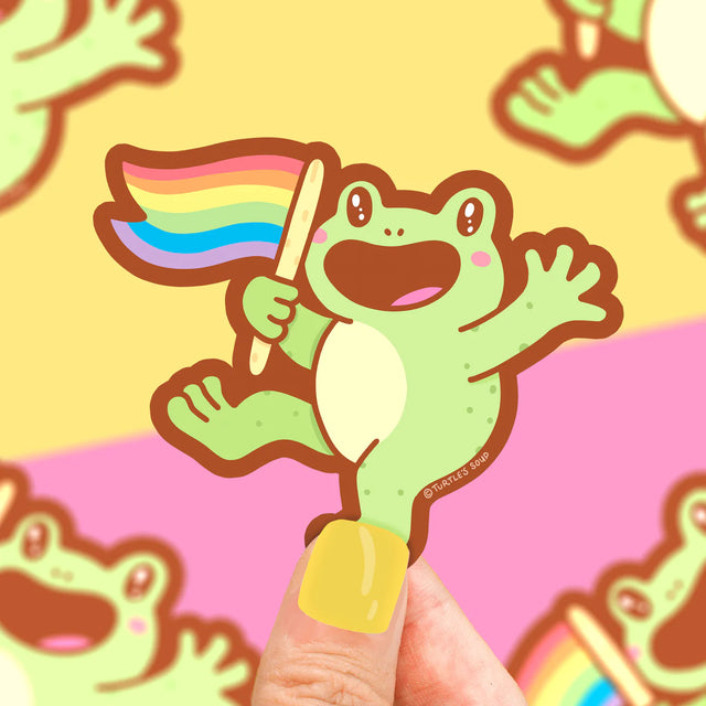 Rainbow Frog Sticker showing a happy green frog holding a waving rainbow pride flag on a colorful background.