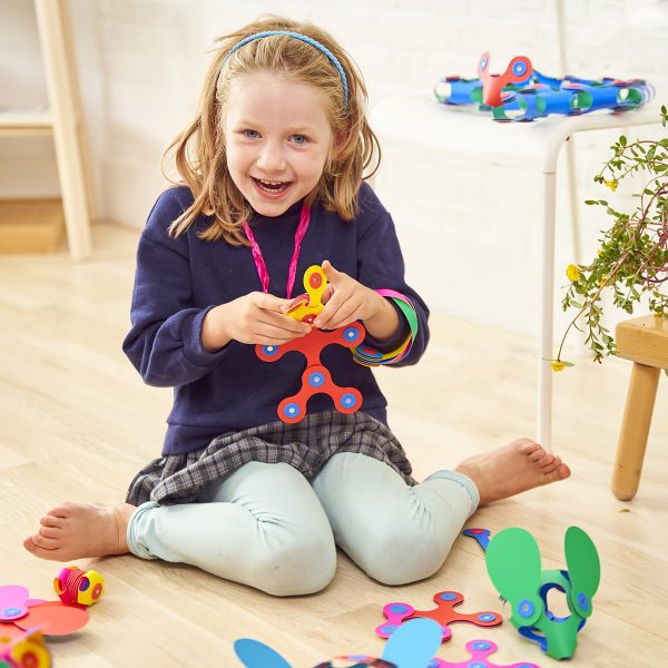 Child playing with colorful Clixo | Rainbow Pack magnetic shapes for creative and wearable STEAM play at home.