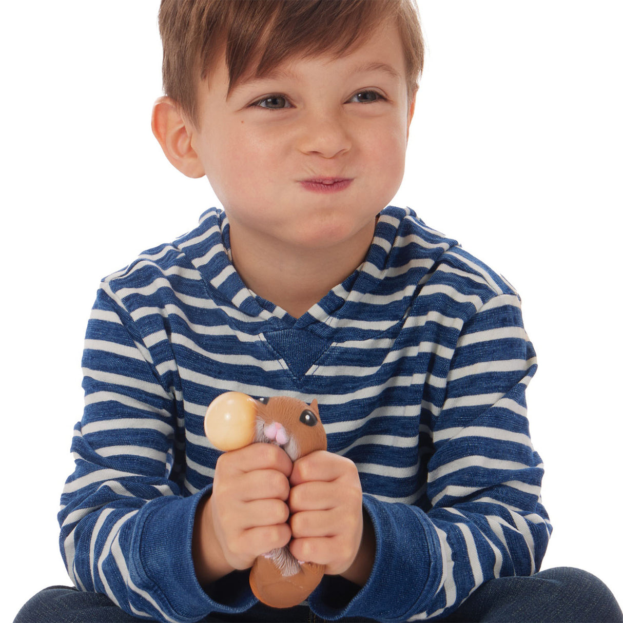 Child squeezing a chubby toy hamster snack in hands smiling happily - Chonky Cheeks Hamster.