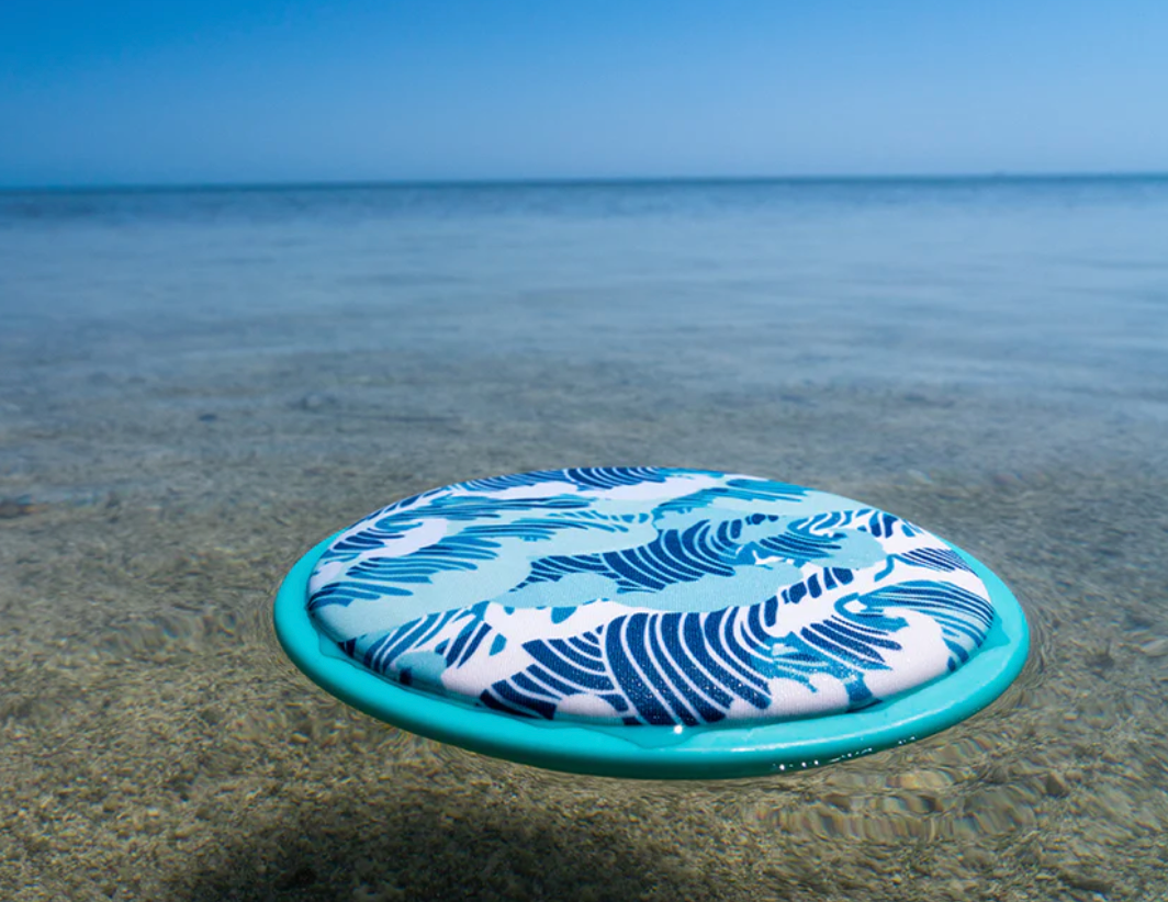Waboba FLOBO Disc floating on clear water, designed for sturdy water play and easy catching at the beach.