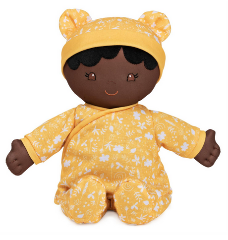 Recycled Baby Doll | Camellia wearing yellow floral onesie with embroidered face and soft floppy body made from recycled materials.