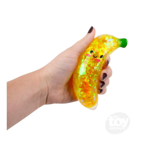 Hand holding a Squeeze Sparkle Banana filled with liquid and sparkly streamers for sensory play and stress relief.