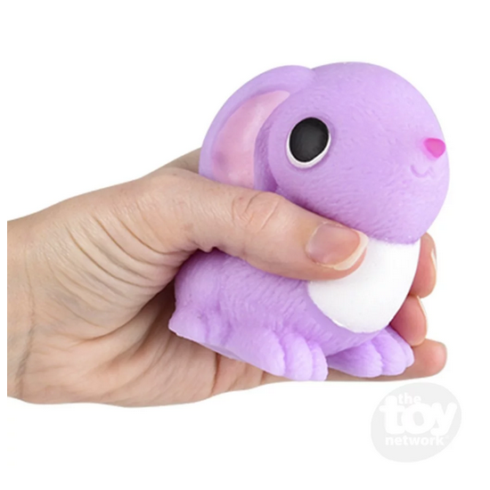 Hand squeezing a purple Squish & Stretch Bunny silicone toy for stress relief and fidgeting.