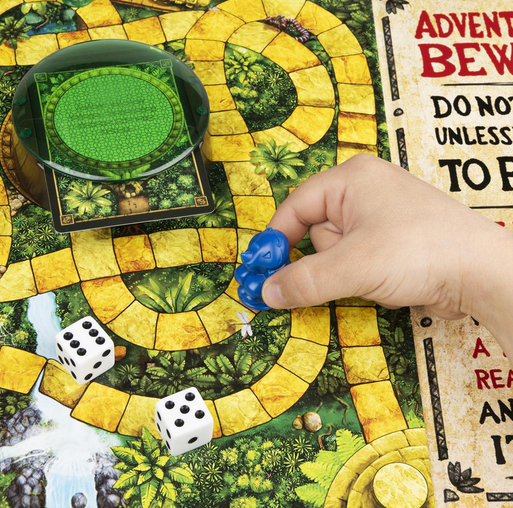 Hand moving blue game piece on jungle path with dice and green dome in Jumanji board game.