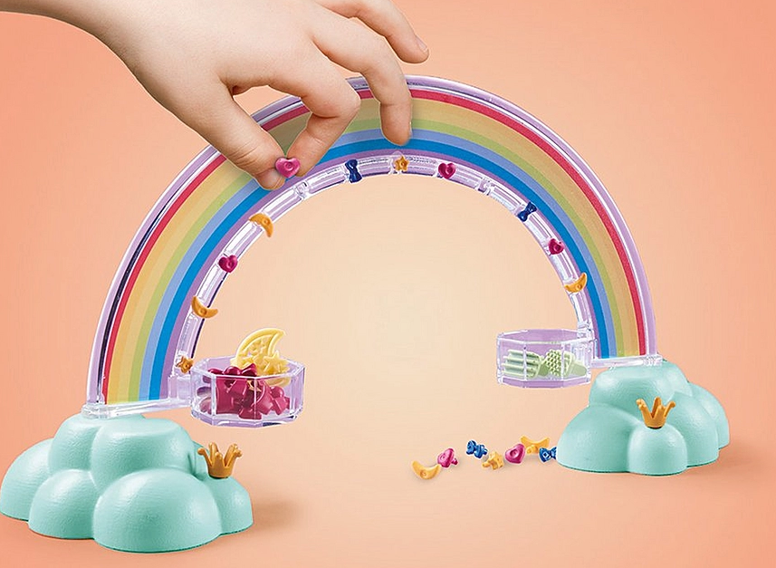 Princess Magic | Rainbow Pegasus Caring Set rainbow arch with jewelry pins and a child's hand placing a pin on it