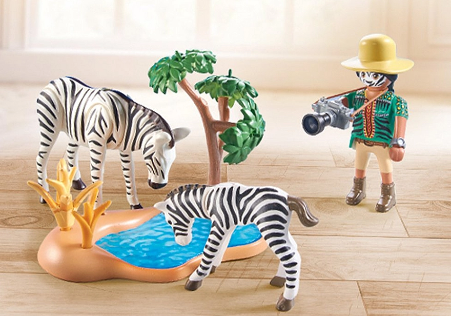 Wiltopia Animal Photographer playset with Sofia in zebra costume, zebras by watering hole, camera, and tree accessory.