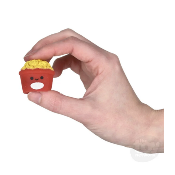 Hand holding a small cute red gummy fast food toy with smiling face, part of Gummy Fast Food collection.