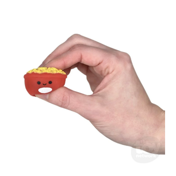 Hand holding a small, cute red bowl with yellow gummy fast food, part of the Gummy Fast Food toy collection.