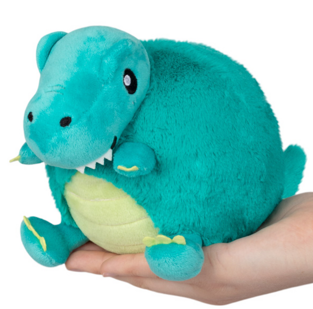 T-Rex Snackers plush squishable dinosaur with soft fur and bean base held in hand, perfect bite-sized squishable toy.