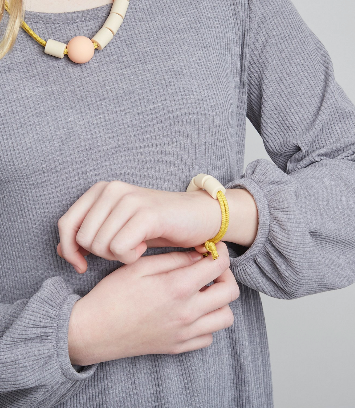 Adventure Sensory Bracelet | Honey worn on wrist, featuring textured non-toxic beads and yellow double layered rope design.