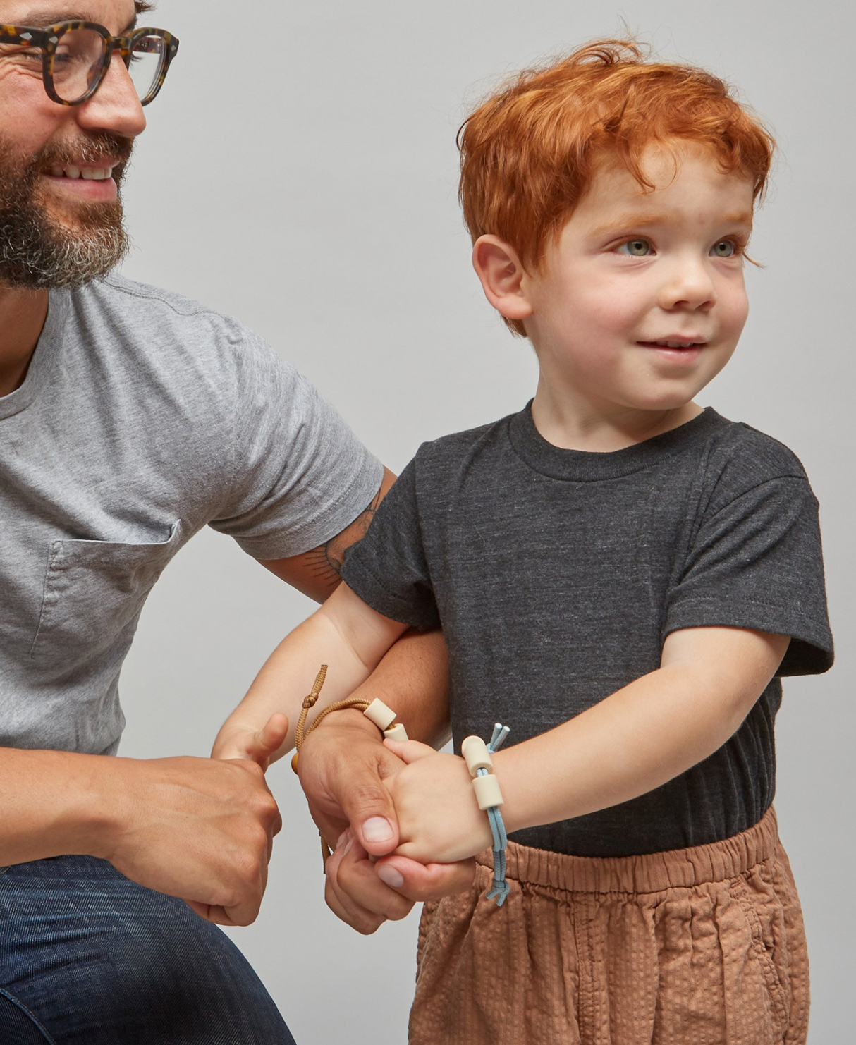 Child wearing the Adventure Sensory Bracelet | Dune with an adult in a casual setting, showing adjustable sensory support.