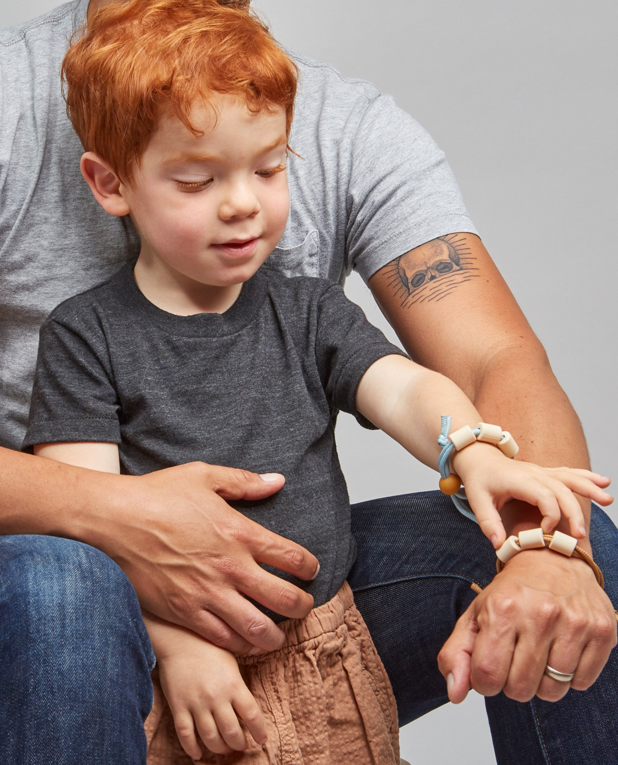 Child wearing the Adventure Sensory Bracelet | Dune with adult, showing adjustable sensory support and style.