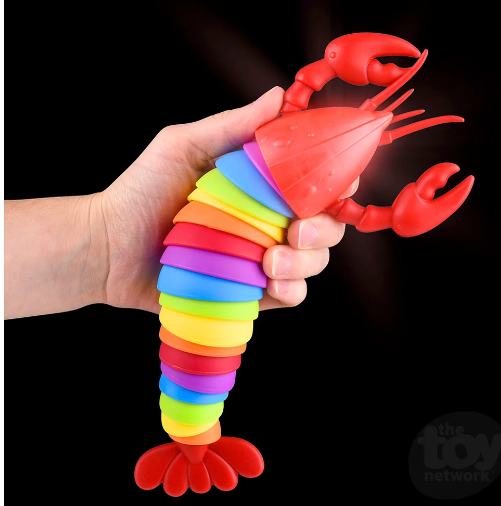 Hand holding a colorful Sensory Wiggle Lobster fidget toy that lights up on impact against a black background
