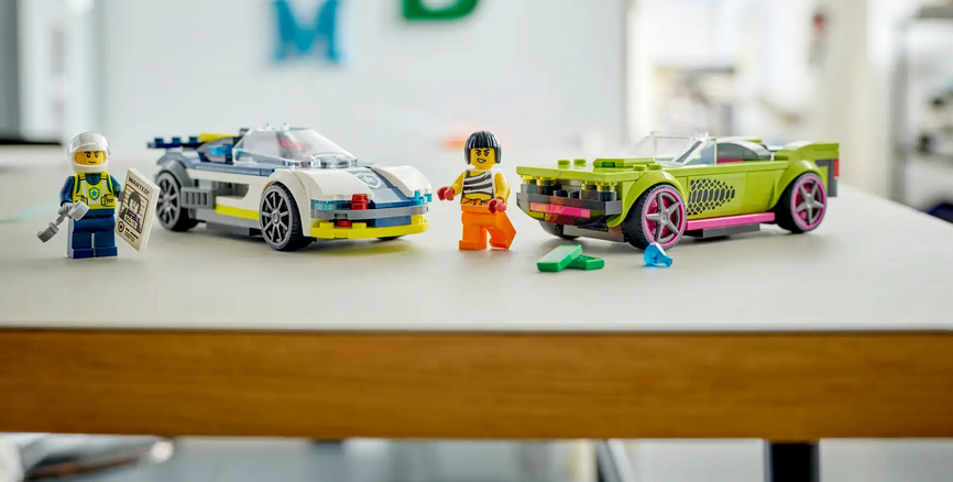 City Police Car and Muscle Car Chase with police interceptor, getaway vehicle, and minifigures on a table for kids' play.