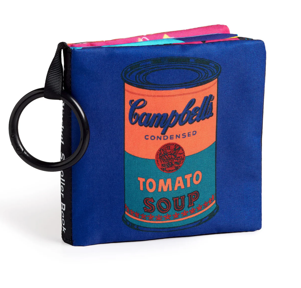 Andy Warhol Crinkle Stroller Book featuring soft fabric pages with iconic Campbell’s Tomato Soup design and stroller clip.