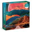 1000pc Cosmic Highway Puzzle box featuring surreal mountain landscape with large red planet in sky and open road below.