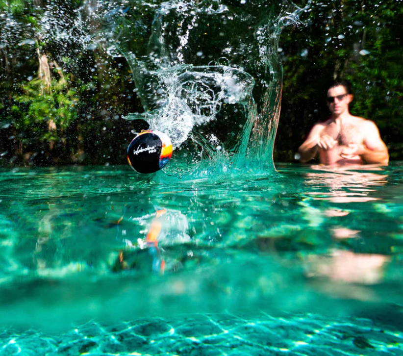 Waboba Pro bouncing on water with a swimmer in background, designed for sport performance and advanced players.