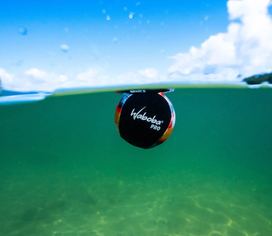 Waboba Pro bouncing on clear water surface showcasing its textured grip and signature gel core design for sport performance.
