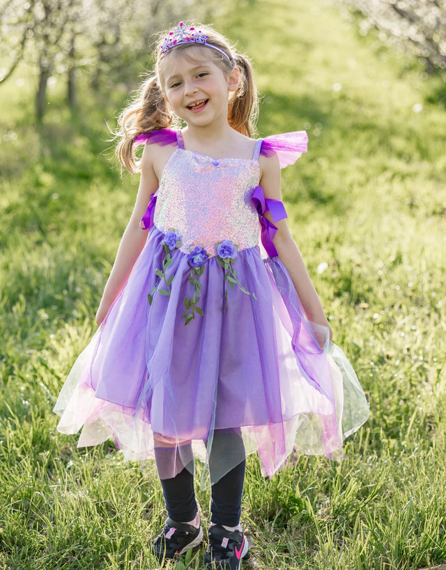 Little girl outdoors wearing the Lilac Sequins Fairy Tunic | Size 5-6 with sparkly sequins and purple ribbon details.