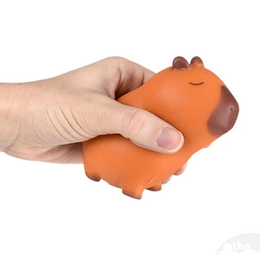 Hand squeezing an orange Squish & Stretch Capybara fidget toy for stress relief and sensory play.