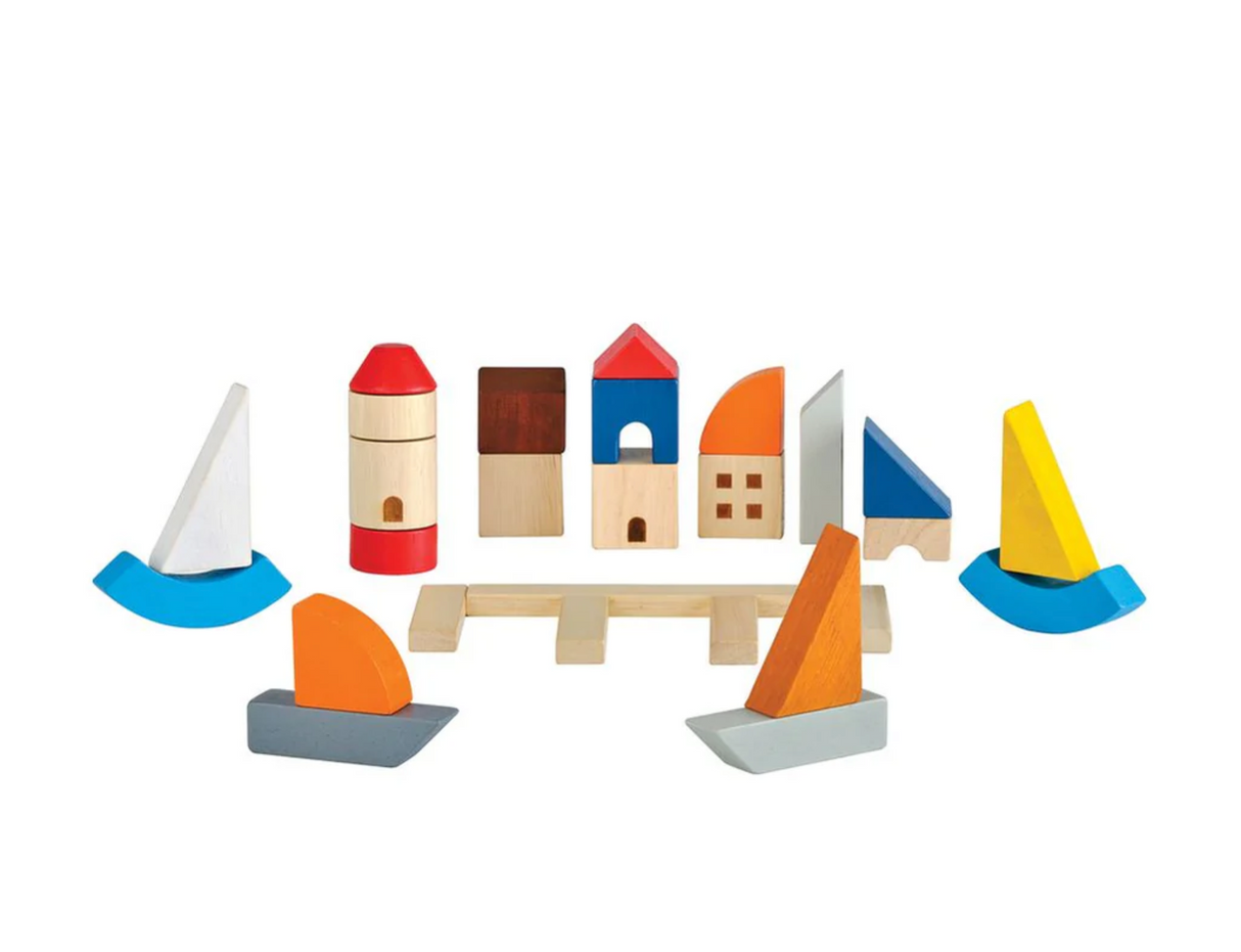 Marina Blocks wooden toy set with colorful sailboats, lighthouse, dock, and buildings for creative play.