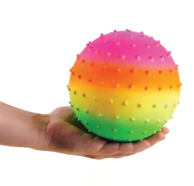 Hand holding a squishy bumpy neon ball in rainbow colors, Knobby Ball | Rainbow inflated to 5 inches.
