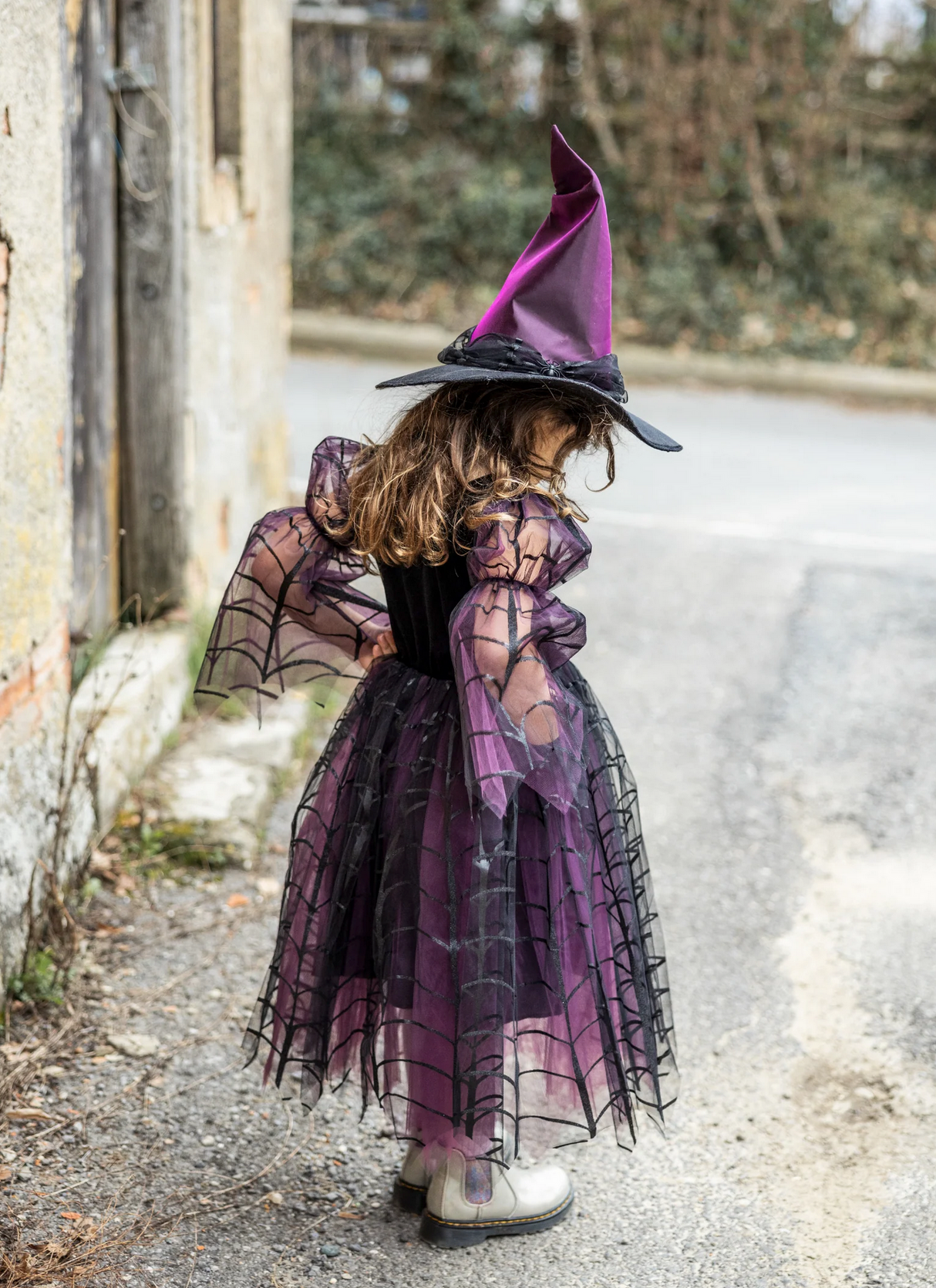 Amethyst the Spider Witch dress and hat with spiderweb patterns and flowing skirt on a child outdoors.
