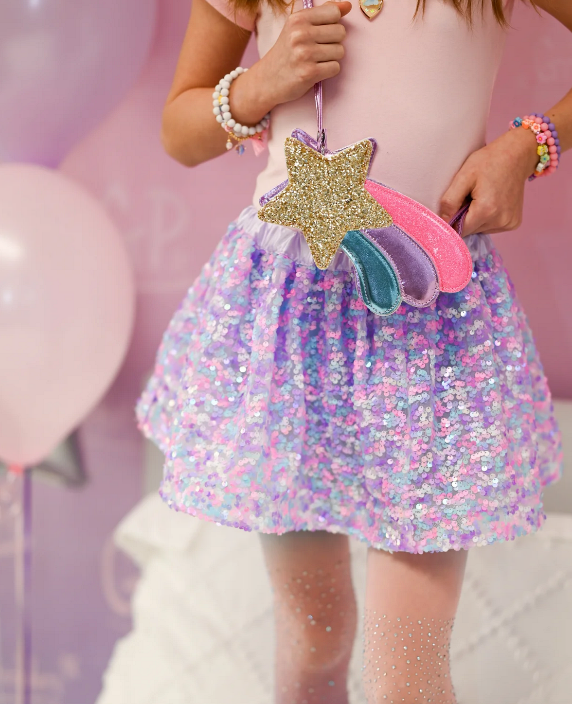 Child holding the Shooting Star Purse with gold star and pink, purple, blue accents, perfect for little hands and magical outfits.