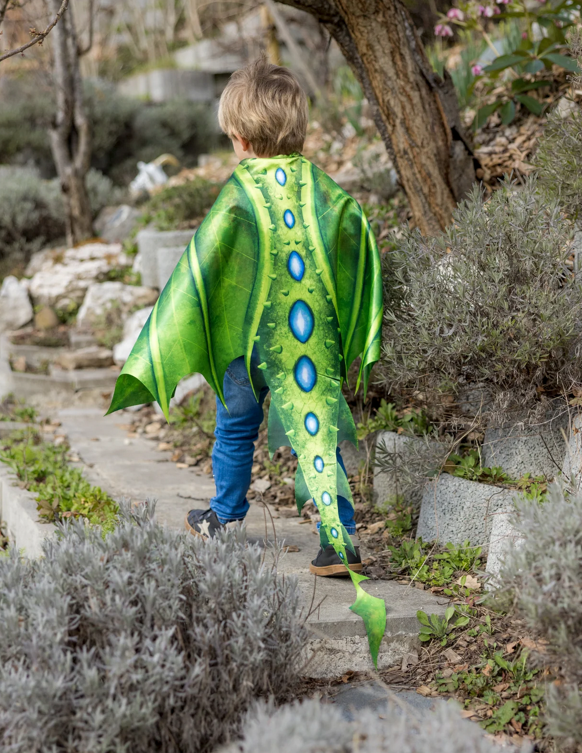 Soft Wings & Mask | Legendary Dragon featuring a child wearing vibrant green dragon wings exploring a garden path.