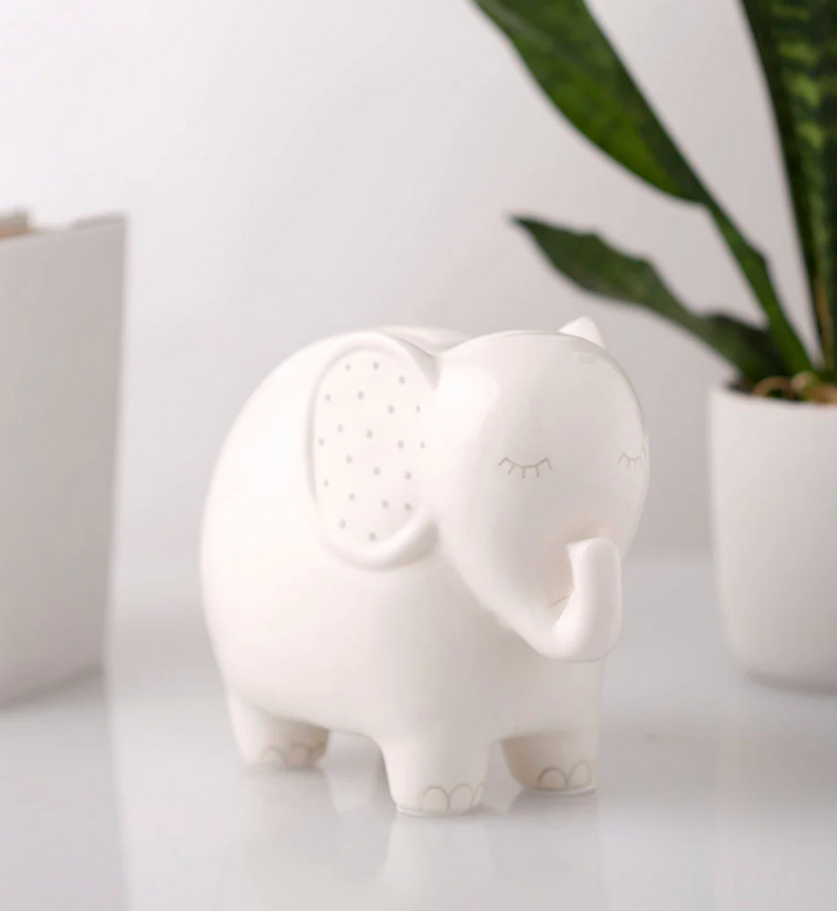 Ceramic Elephant Money Bank in white with gray accents, featuring a removable stopper for safe savings.