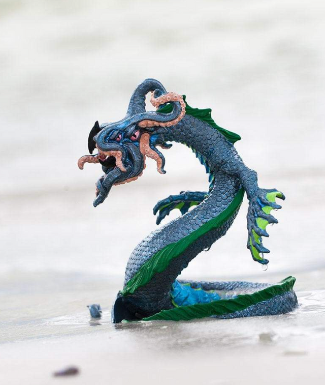 Leviathan figurine with coiled sea serpent body, four-eyed squid-like face, and detailed tentacles poised to strike.