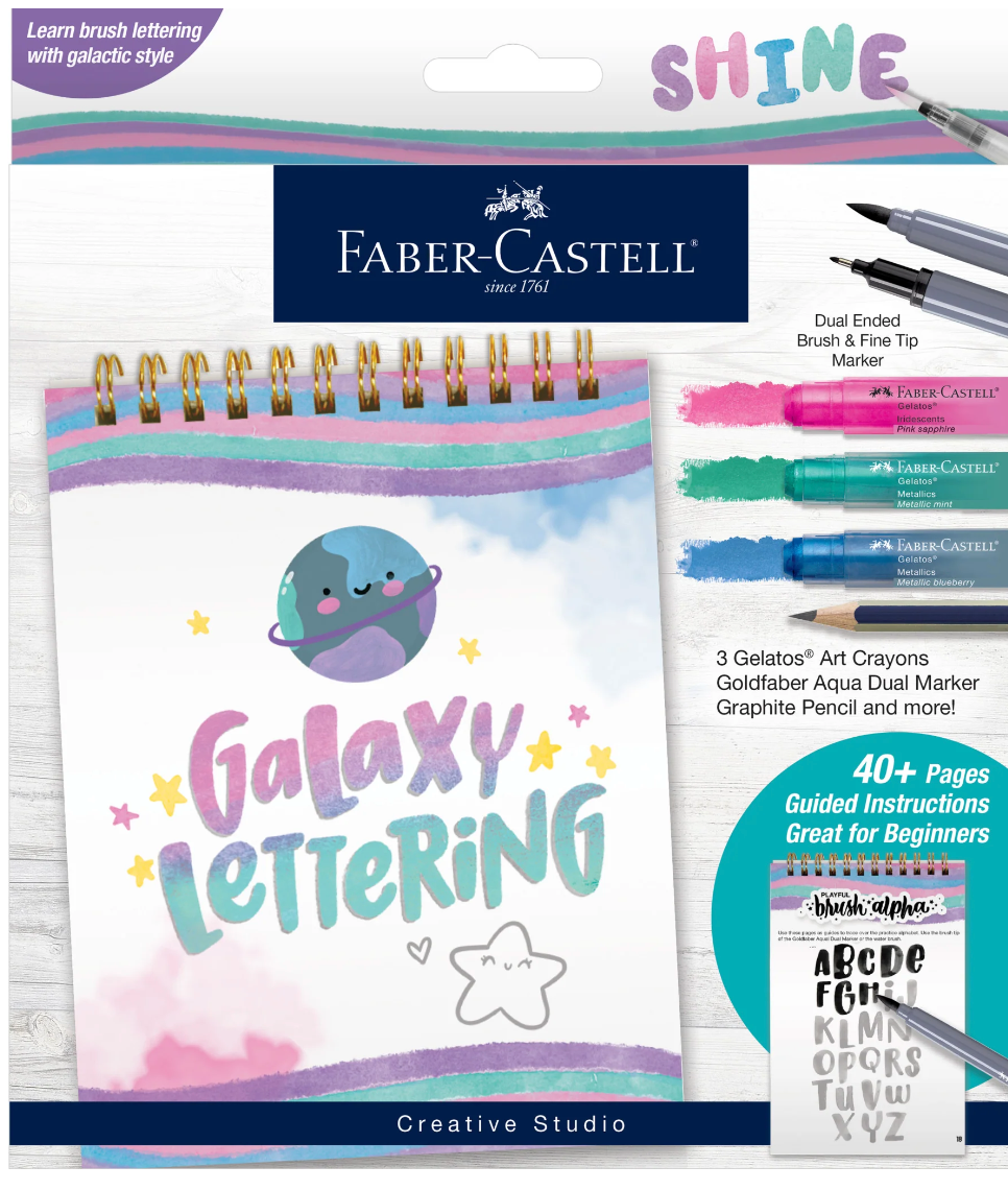Galaxy Lettering Kit with spiral-bound activity book and art crayons for learning galactic brush lettering and calligraphy basics.